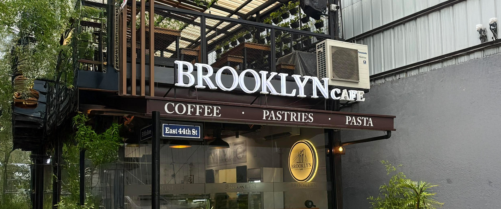 The Brooklyn Cafe storefront with its lit sign reading Coffee · Pastries · Pasta