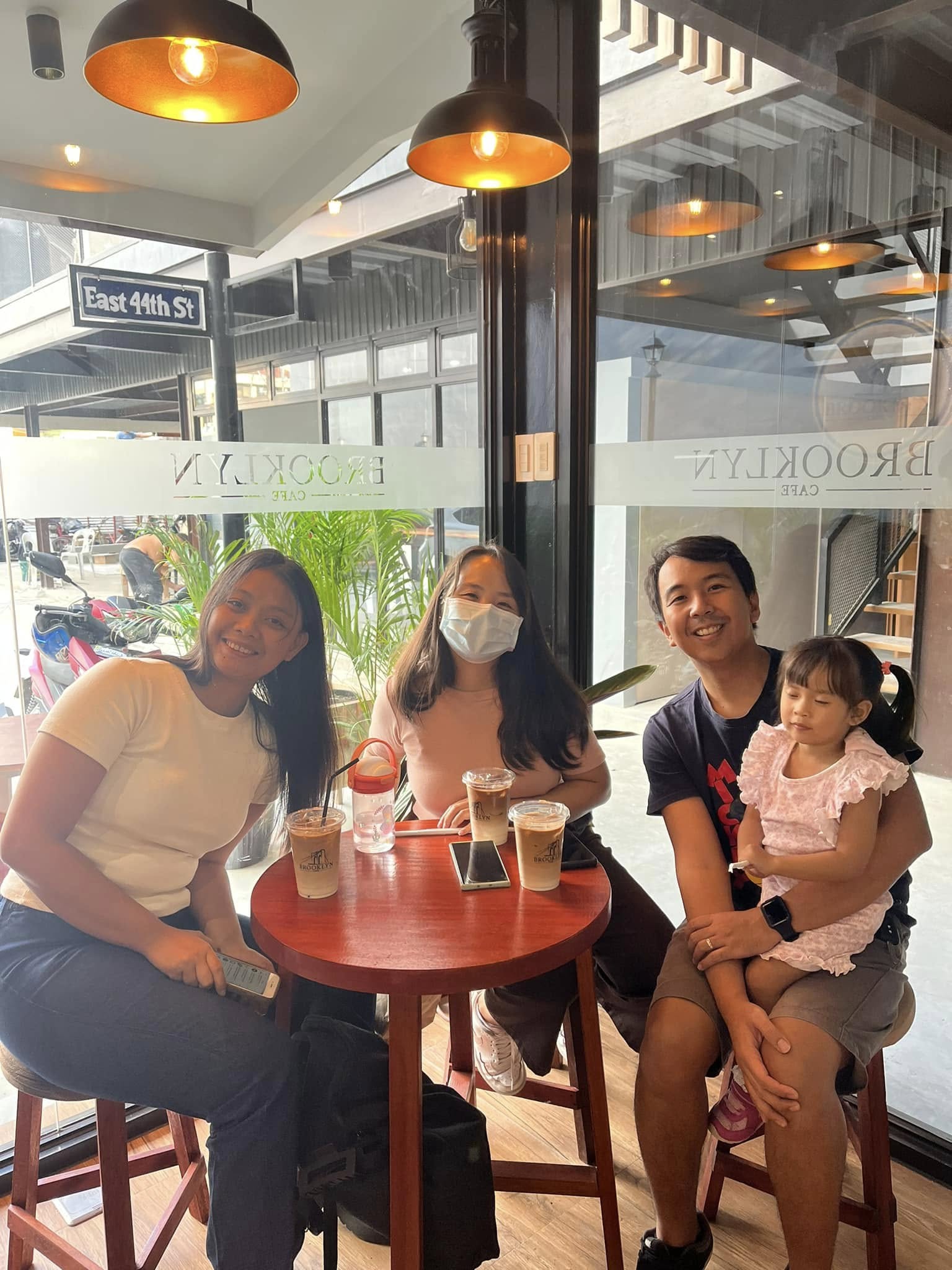 Four guests with iced drinks at an outdoor table